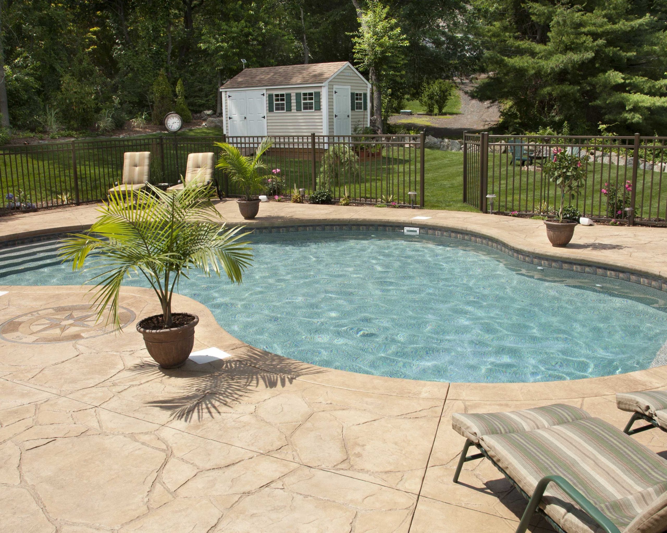A decorative concrete pool deck designed and constructed by professional concrete contractors.